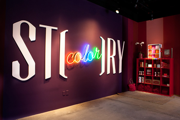 Store logo with "color" written in rainbow lights contained within the word "story"