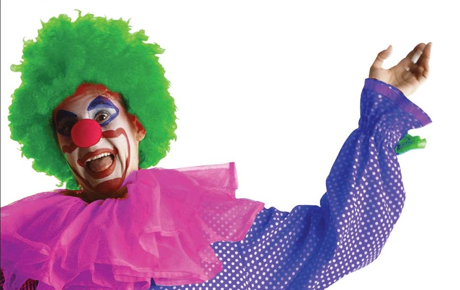 Photo of clown with green hair and pink and purple shirt