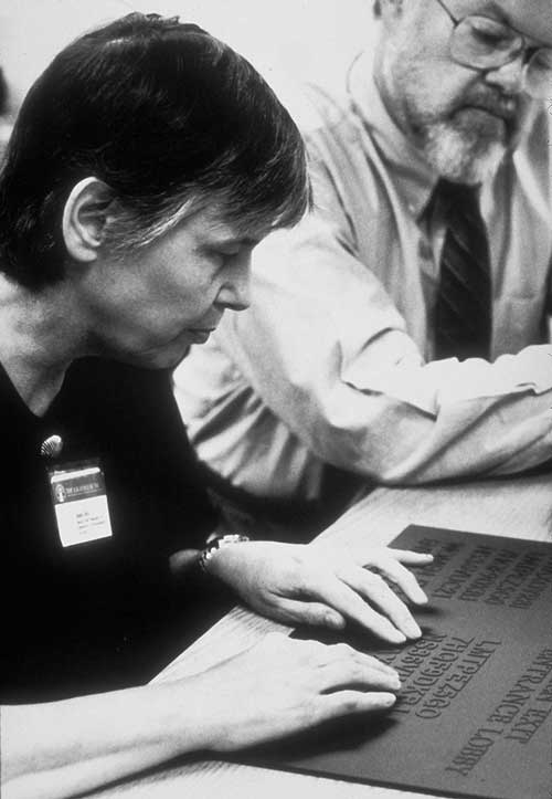 a woman reading raised letters with her fingers