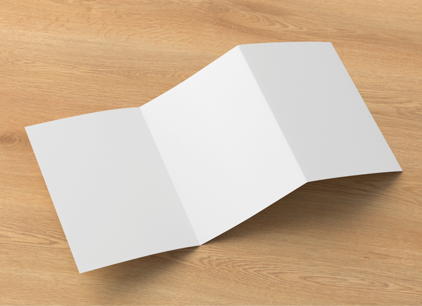 Photograph of blank tri-fold (accordion fold) on textured wood background.