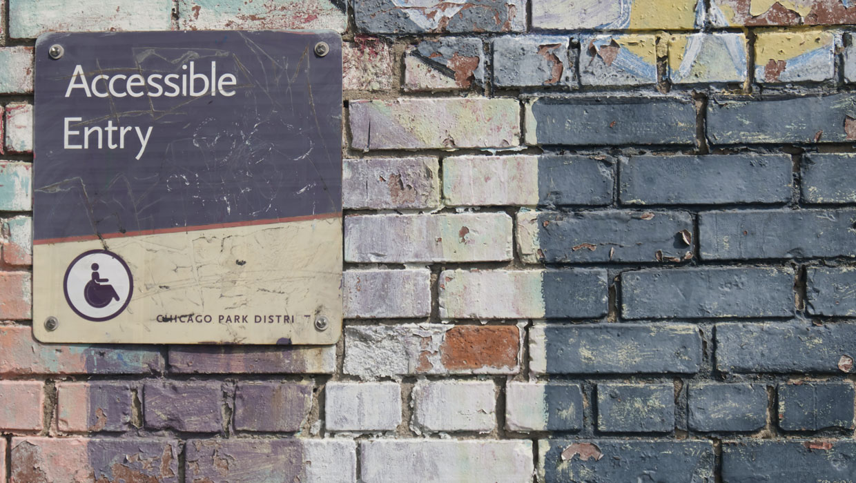 brick wall with sign marking accessibly entry