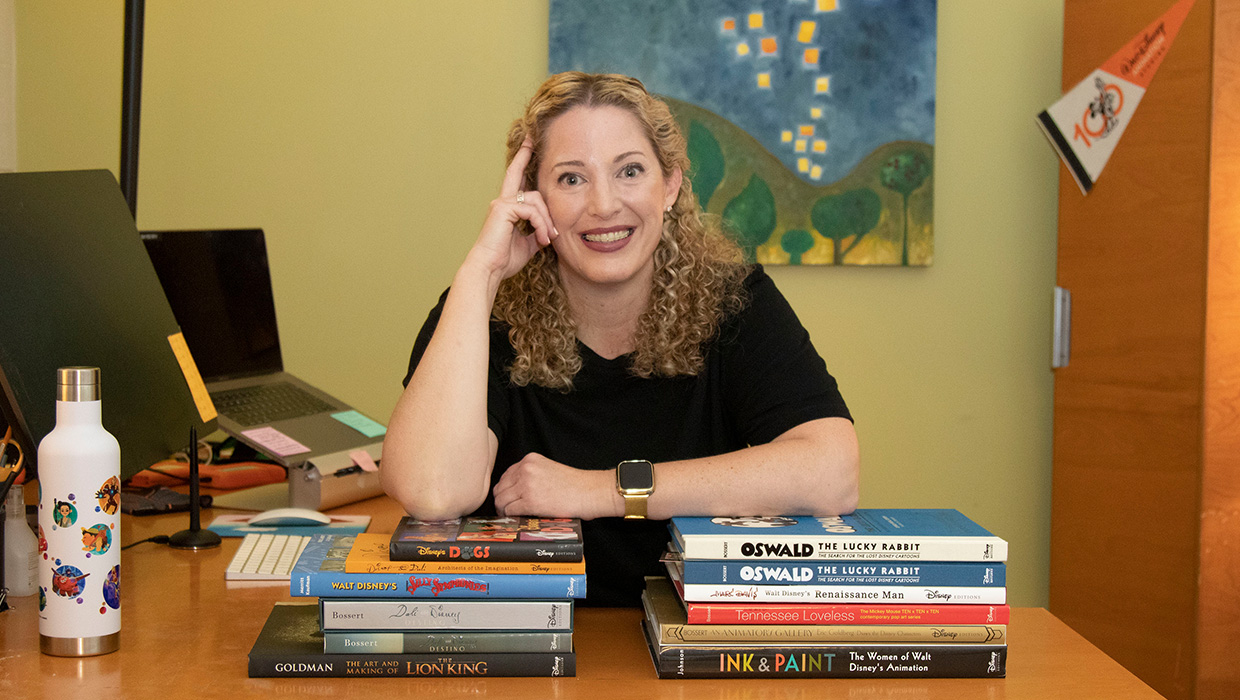 designer Tamara Khalaf posing with the books she has designed for Disney Animation