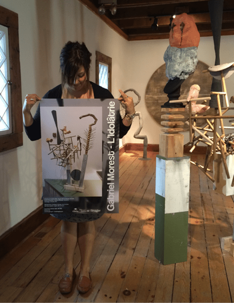 Figure 1. Izzy Poirier with one of her art gallery poster designs